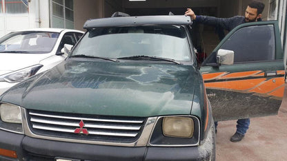The visor on the windshield (gloss black, 5mm) for Mitsubishi L200 1996-2006 - Reelken Auto